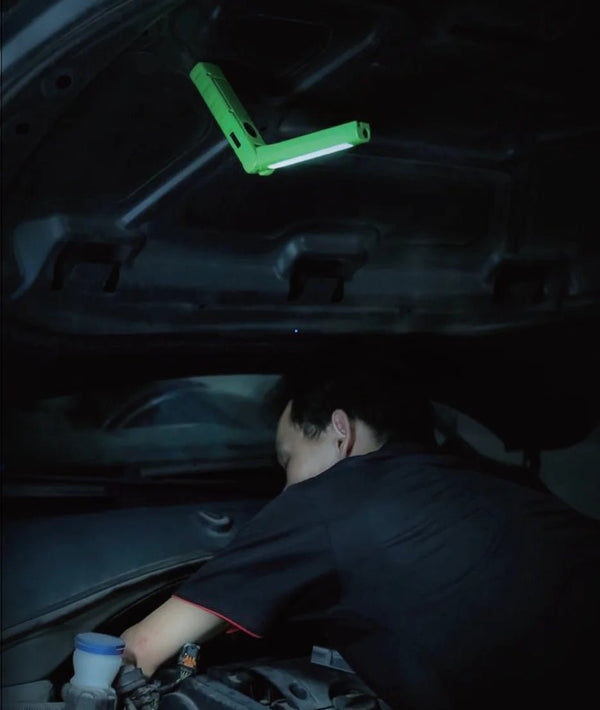 Mechanic working under a car hood illuminated by a Realite RL550 LED Rechargeable Flashlight 500Lumens