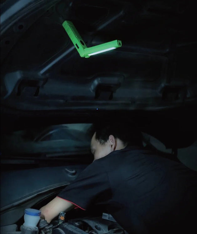Mechanic working under a car hood illuminated by a Realite RL550 LED Rechargeable Flashlight 500Lumens